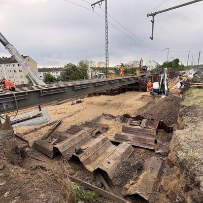 Eine Gleisbaustelle. Im Hintergrund ragt ein Kran hervor.