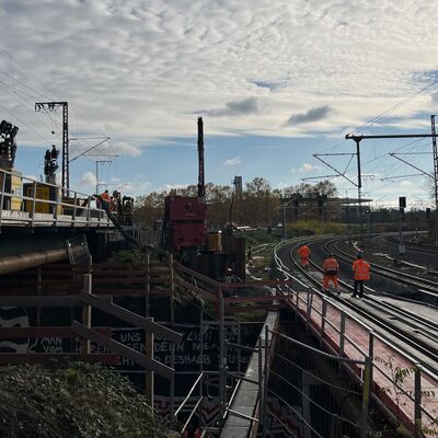 Über eine Hilfsbrücke stehen drei Personen in Warnwesten.
