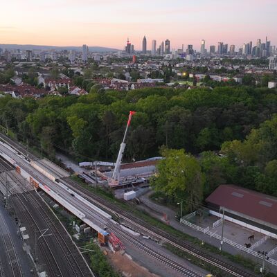 Drohnenbild auf eine Gleisbaustelle. Im Hintergrund ist die Frankfurter Skyline.